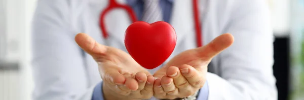 Male medicine doctor hands holding and covering red toy heart — Stock Photo, Image