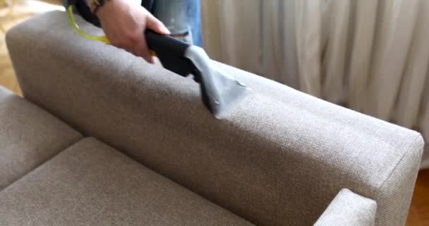 Männliche Haushälterin putzt Sofa mit Waschsauger — Stockvideo