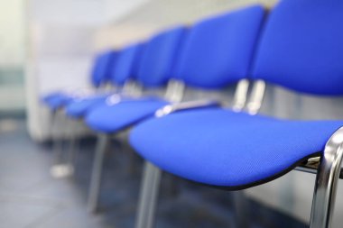 Resepsiyonda veya bankada boş mavi ziyaretçi koltukları kuyruğu