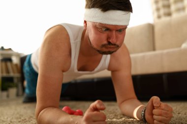 Erkekler oturma odasında yerde şınav çekerler.