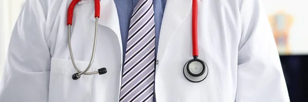 Stethoscope lying on male therapeutist doctor chest — Stock Photo, Image