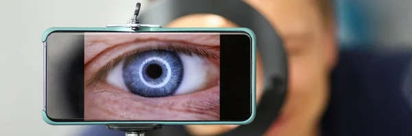 Muž dělat video se snaží střílet své vlastní oko pomocí moderní smartphone kamery — Stock fotografie