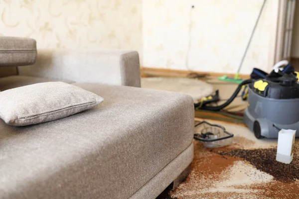 Sofa berdiri di ruangan domestik dengan vacuum cleaner profesional di latar belakang — Stok Foto