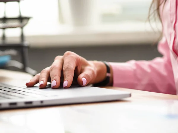 Vrouwelijke hand met mode manicure ligt in de buurt laptop — Stockfoto