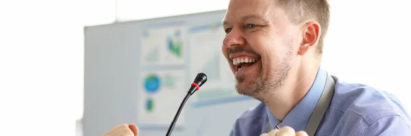 Guy in front of a microphone and smiling at public — Stock Photo, Image