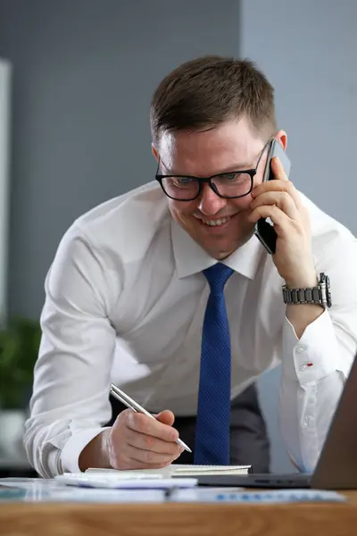 Empresário falando por telefone escrevendo informações — Fotografia de Stock