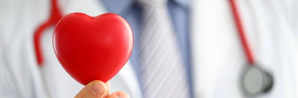 Male medicine doctor hands holding and covering red toy heart — Stock Photo, Image