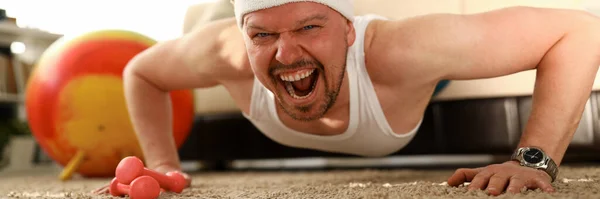 Hombre haciendo ejercicio en casa, entrenando a un hombre deportivo —  Fotos de Stock