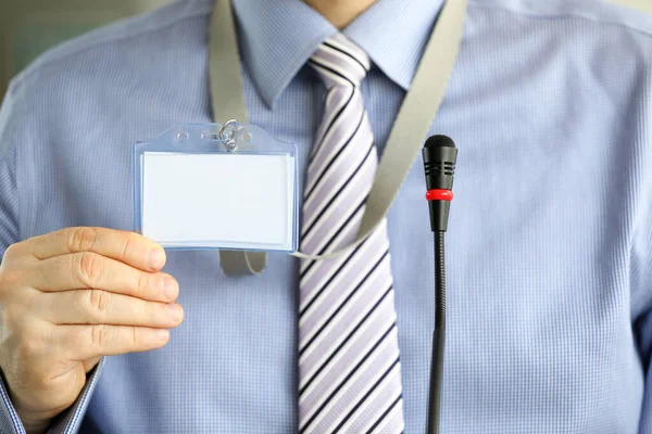 Man in tie shows blank badge attending seminar — Stock Photo, Image