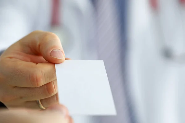 Männlicher Arzt hält weiße Blanko-Visitenkarte in der Hand — Stockfoto
