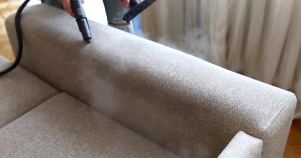 Мужчина уборщица ручной чистки диван с кистью на пару крупным планом — стоковое видео