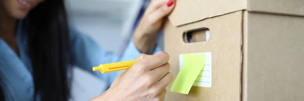 Happy woman holding yellow pen — Stock Photo, Image