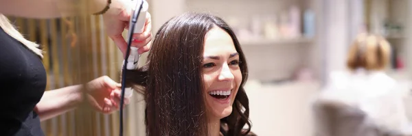 Hair stylist using curling iron — Stock Photo, Image