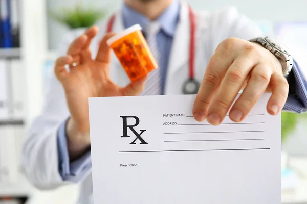 Мужской врач держит банку с таблетками — стоковое фото