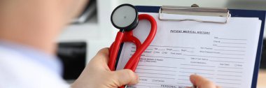 Erkek doktor elinde gümüş kalemle yazı tutuyor.