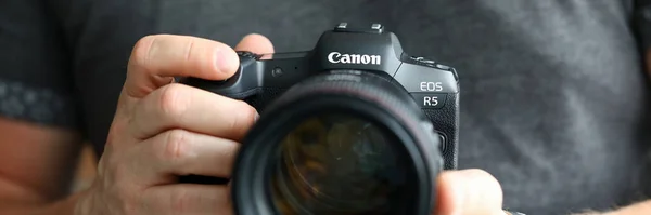 Hombre de la mano celebración de la marca nueva cámara digital sin espejo Canon r5 primer plano — Foto de Stock