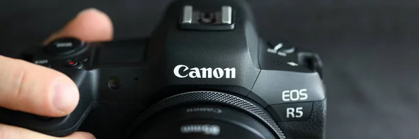 Hombre de la mano celebración de la marca nueva cámara digital sin espejo Canon r5 primer plano — Foto de Stock