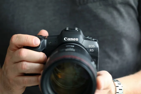 Hombre de la mano celebración de la marca nueva cámara digital sin espejo Canon r5 primer plano — Foto de Stock