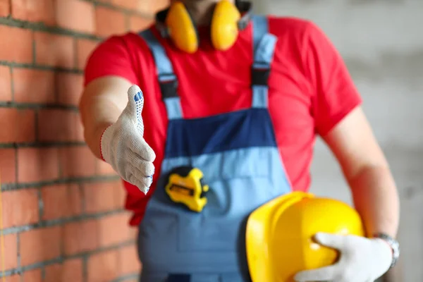 Construtor em objeto segura sua mão para cumprimentar — Fotografia de Stock