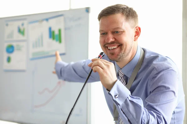 Homem de negócios rindo mostrando gráficos e diagramas — Fotografia de Stock