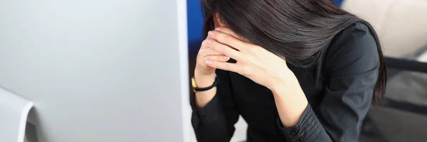 Upset woman bowed her head in front of the monitor