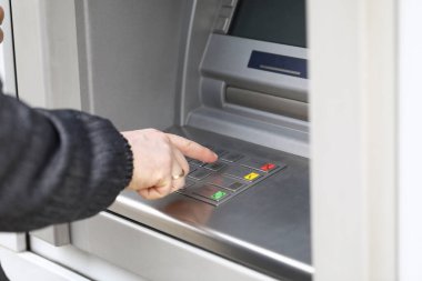 Adam ATM 'den para çekmek için PIN kodunu çeviriyor