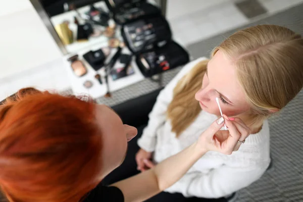 Vrouwelijke make-up kunstenaar corrigeert model oog make-up — Stockfoto