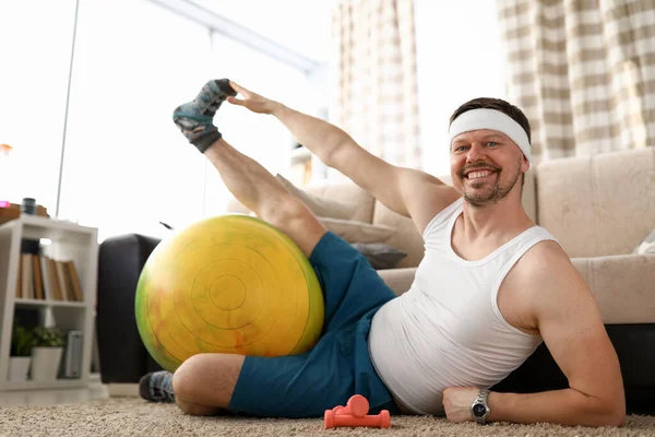 Homme à la maison faire de remise en forme avec haltères et ballon — Photo