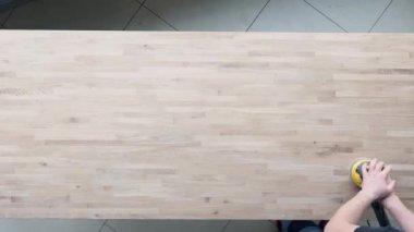 Ahşap masayı yağla kaplayan iki adamın videosu.