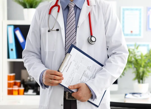 Stetoskop ležící na mužské hrudi lékaře v úřadu — Stock fotografie