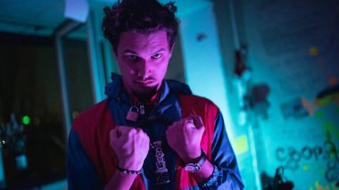 Genç ciddi Mısırlı adam neon partisinde dövüşmeye hazırlanıyor. Yeraltı çevresi