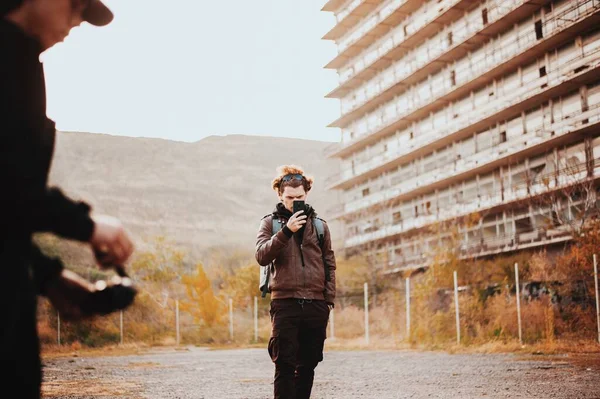 Homme bouclé filmant des amis au coucher du soleil sur le téléphone — Photo