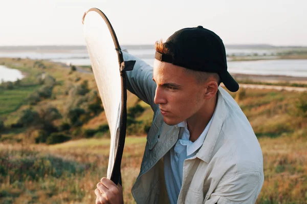 Young lighting guy in cap holds reflector — Stock Photo, Image