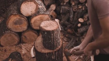 Sakallı havalı kel adam balta ile yakacak odun kırıyor, ters yönde etkileyici bir yumruk.