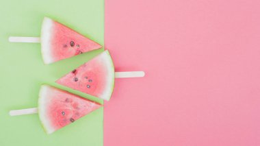 karpuz dilimi sopa ile yeşil ve pembe arka plan üzerinde