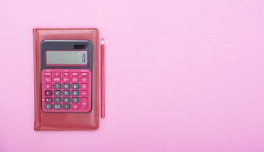 Kırmızı calclator kırmızı kalemle üstten görünüm canlı pembe arka plan masada boş kopya alanı, matematik, maliyet, vergi veya yatırım hesaplama.
