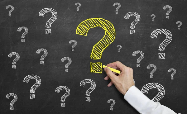 öğretmen tahtaya bir sarı soru işareti çizim