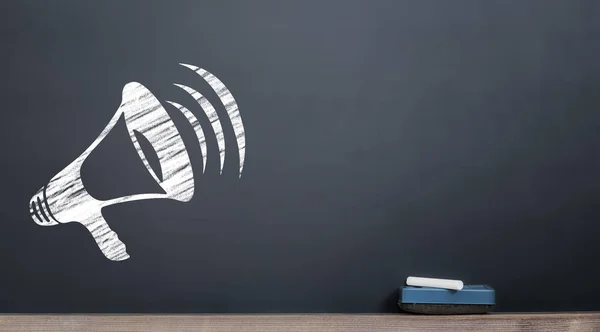 Megaphone icon on the chalkboard with chalk and eraser — Stock Photo, Image