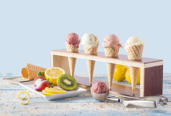 ice cream varieties in cornet with fruits on blue table