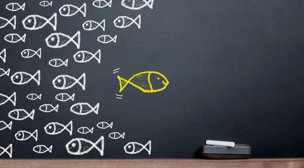 Goldfish goes the opposite direction of the other fish.innovatio — Stock Photo, Image