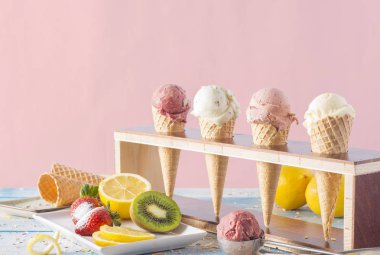 pembe arka plan üzerinde limon kivi ve çilekli dondurma kornet