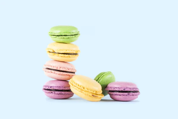 Macarons in einer Reihe gestapelt isoliert auf blauem Hintergrund — Stockfoto