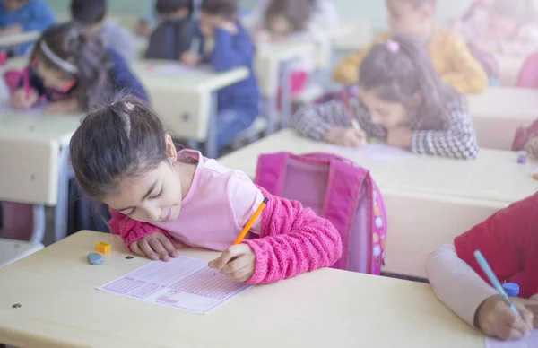 elementary school girl filling optical form in classroom