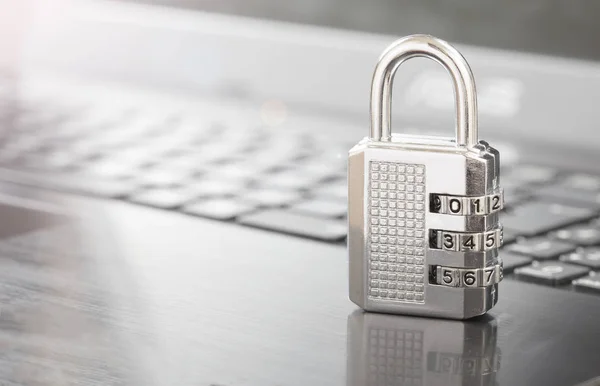 silver combination lock on keyboard.cyber security concept