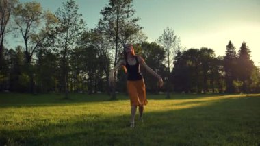 Atlama ve bir parkta açık dans uzun kırmızı etek çekici erkek