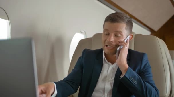 幸せ豊かな成熟したビジネスマン ビジネス ジェットで旅行中と電話で会話をしています。 — ストック動画