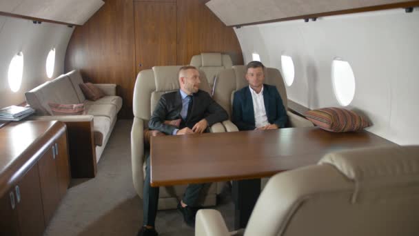 Dos hombres de negocios hablando, sentados en jet privado . — Vídeo de stock