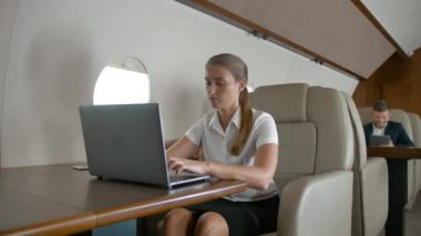 Uçakta dizüstü kullanarak iş kadını