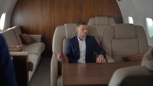 Les hommes d'affaires à l'intérieur du jet privé se détendre tout en volant et en parlant avec l'hôtesse — Video