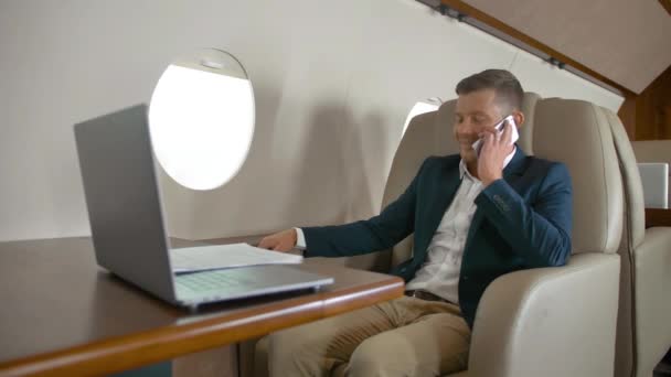 Mogen entreprenör talar av mobiltelefon partner anslutning flygplan jet resa — Stockvideo